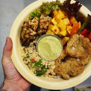 Crispy mushroom bulgar wheat bowl with zesty charred cauliflower, roasted bell pepper, pickled chilli mango, and a pomegranate ginger turmeric cbd vinaigrette from Eat Genesis in London